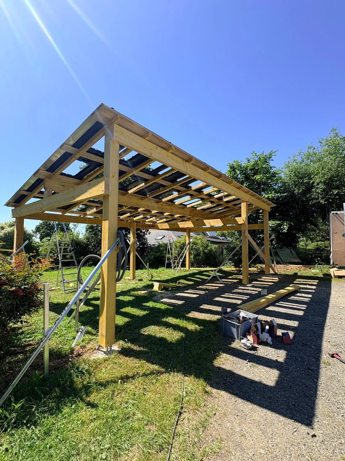 Panneaux solaires : ossature bois du carport et panneaux en sous-face